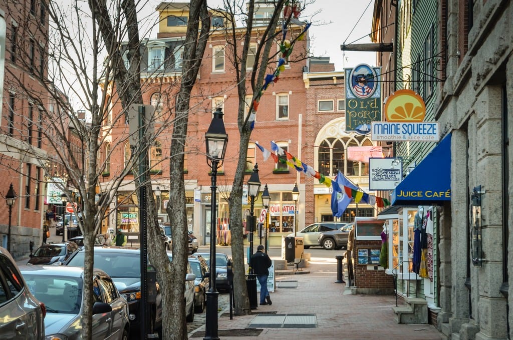 A street with boutiques on it in Portland, Maine, old-fashioned gas lamps on the street.