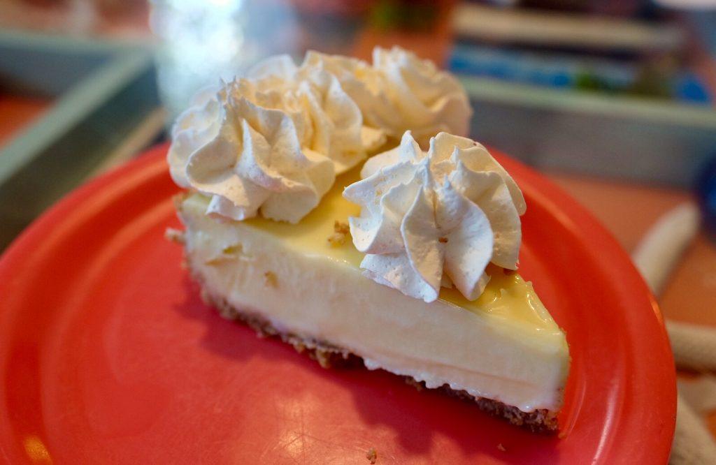 A slice of key lime pie topped with whipped cream.