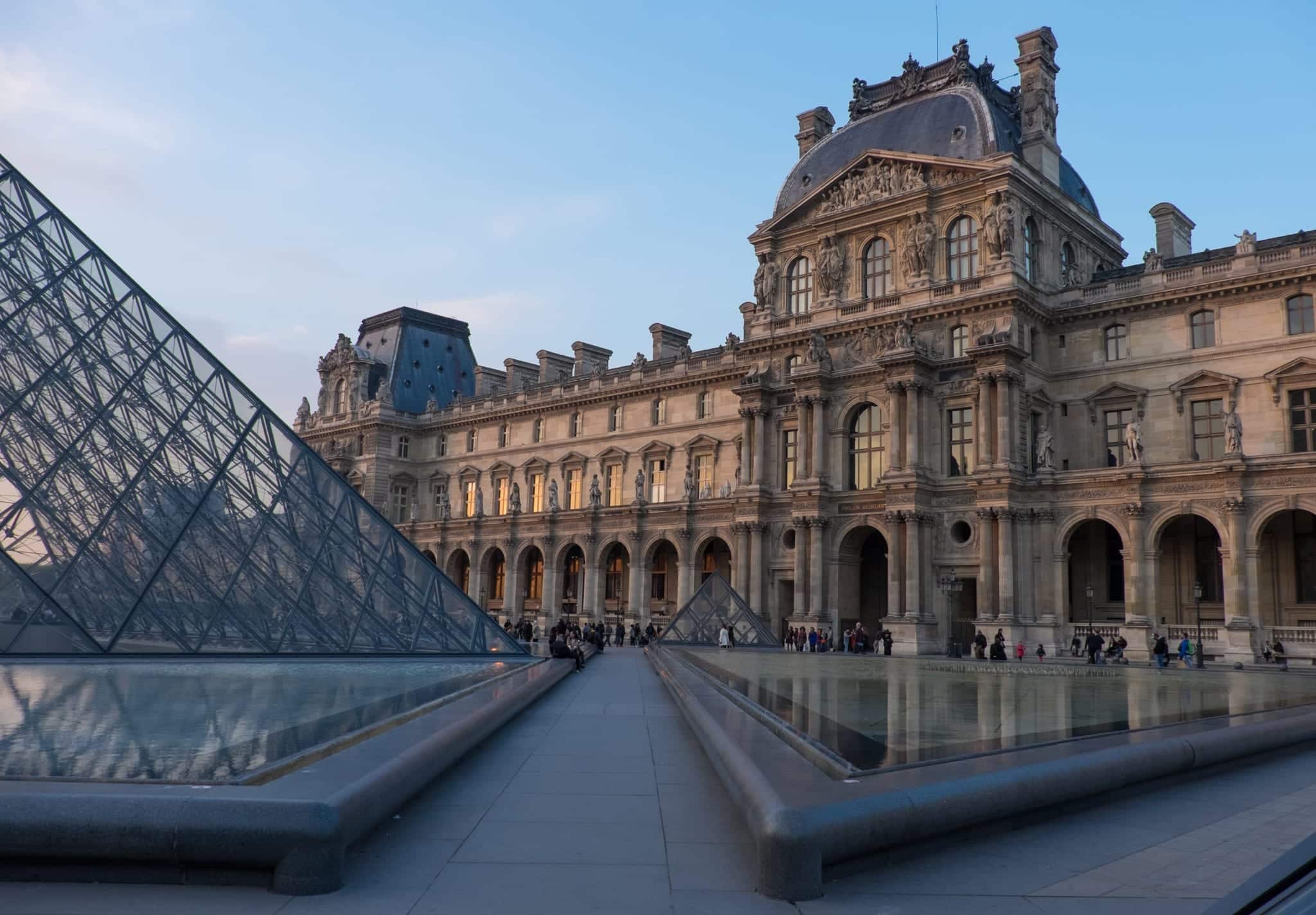 The Louvre's old-fashioned building next to its modern glass pyramid.