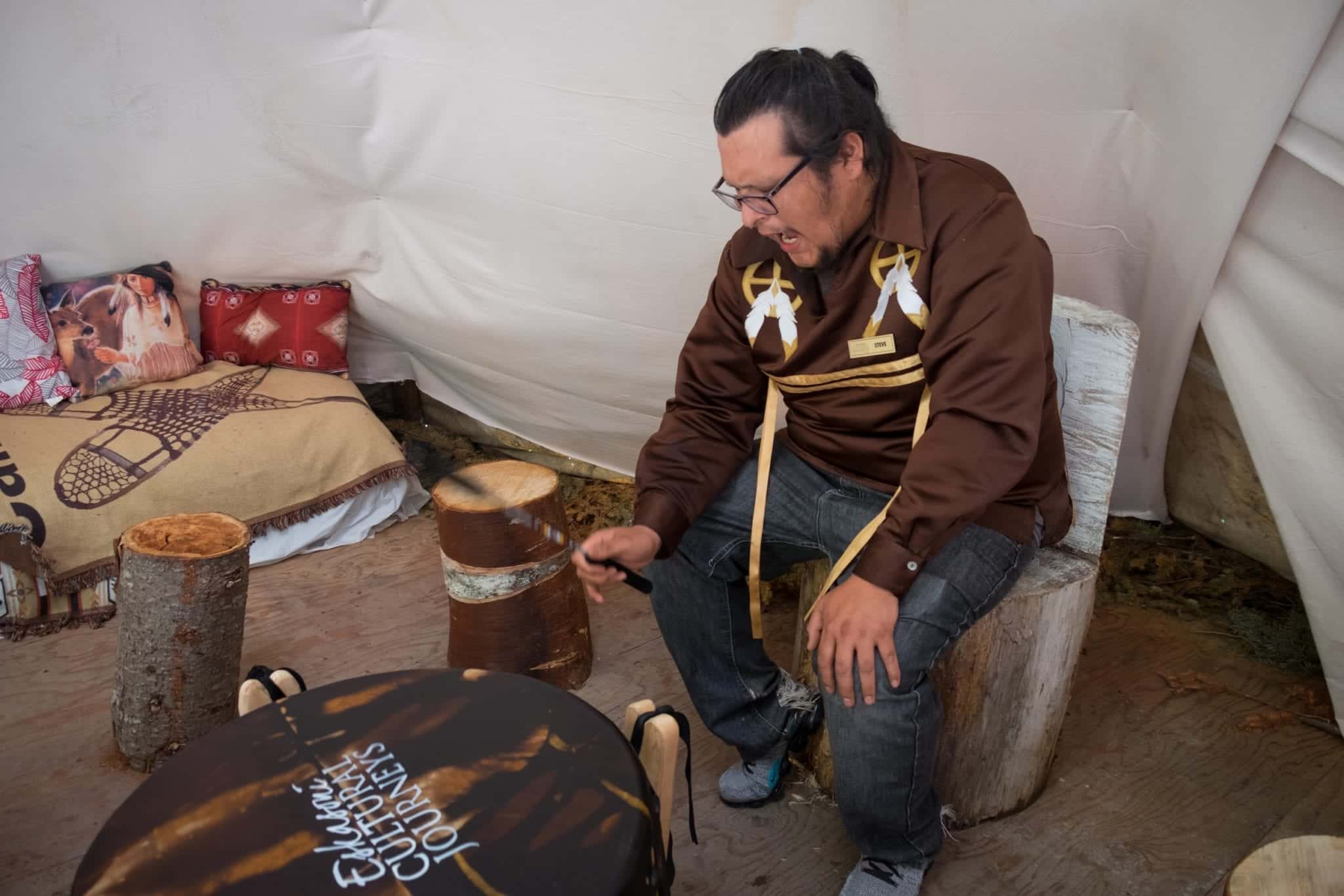 A Mi'kmaq man plays a drum and sings.