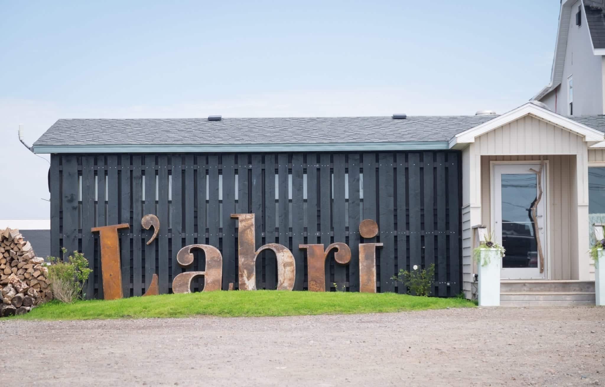Giant letters reading L'abri in front of a one-story restaurant