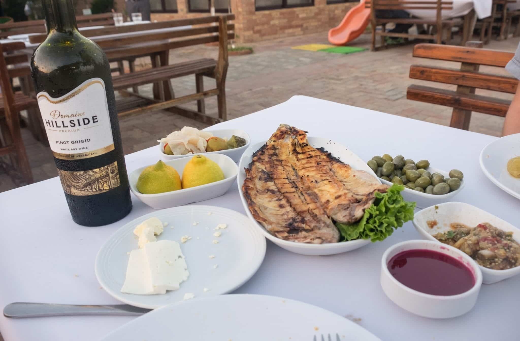 A meal at Derya Fish house: fish, wine, and several vegetable dishes and bread.