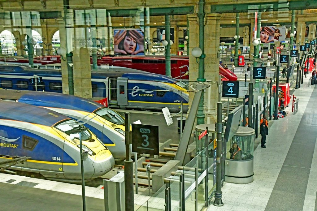 Yellow and blue Eurostar trains lined up at Gare du Nord in Paris.