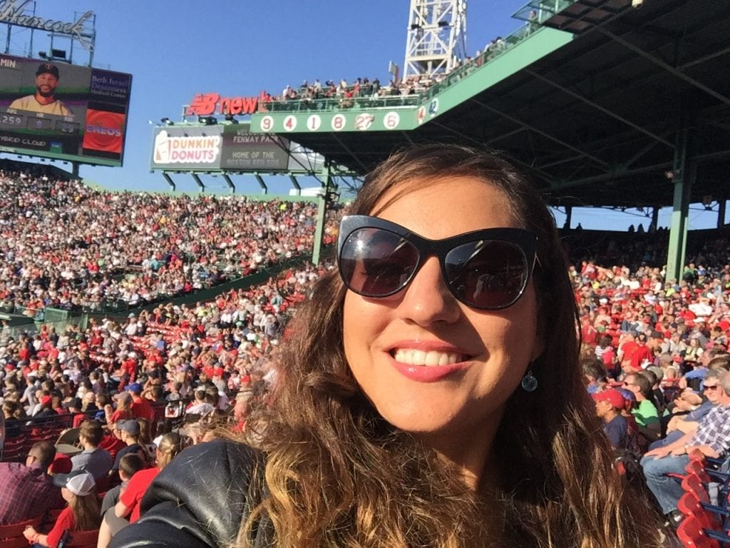 Kate takes a selfie at Fenway Park, where the Red Sox play, lots of people wearing red in the background.