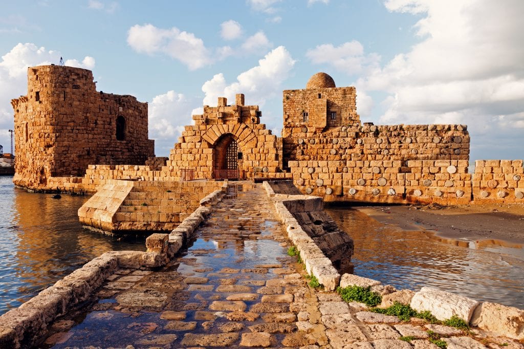 Sidon's Sea Castle: you see a small stone building kind of looking like a fort, placed out in the sea. Leading to the castle is a stone pathway above the water.