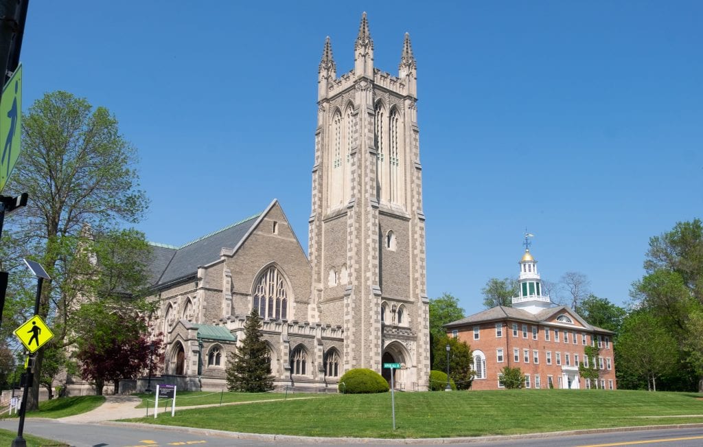 The Williamstown campus: a gray church with a tall bell tower next to a red brick building with a gold dome.